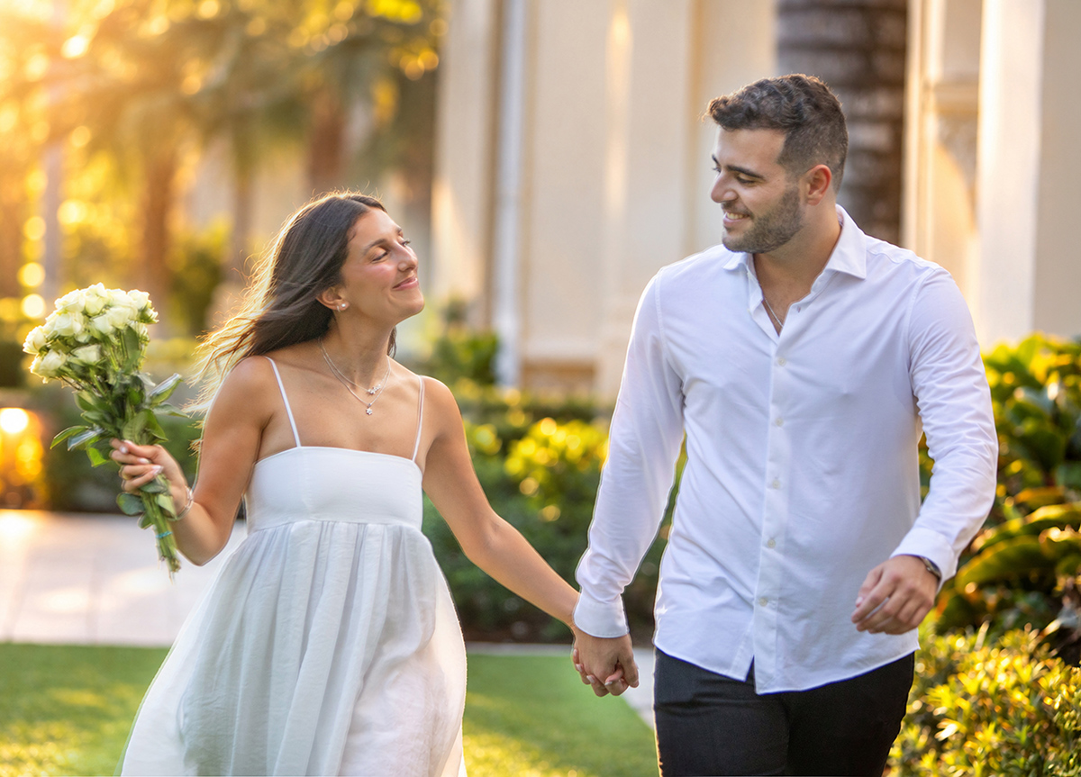 Brandon and Sydnie walking hand in hand during their golden hour engagement portraits at The Boca Raton
