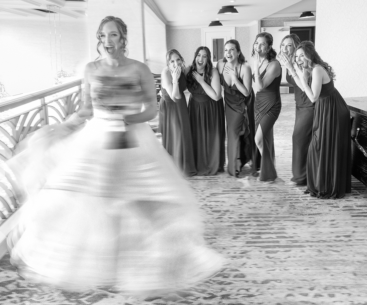 Bride spinning in her wedding dress while bridesmaids react with joy during getting ready photos at the Renaissance Hotel Plantation — captured by South Florida wedding photographer Jeff Kolodny.