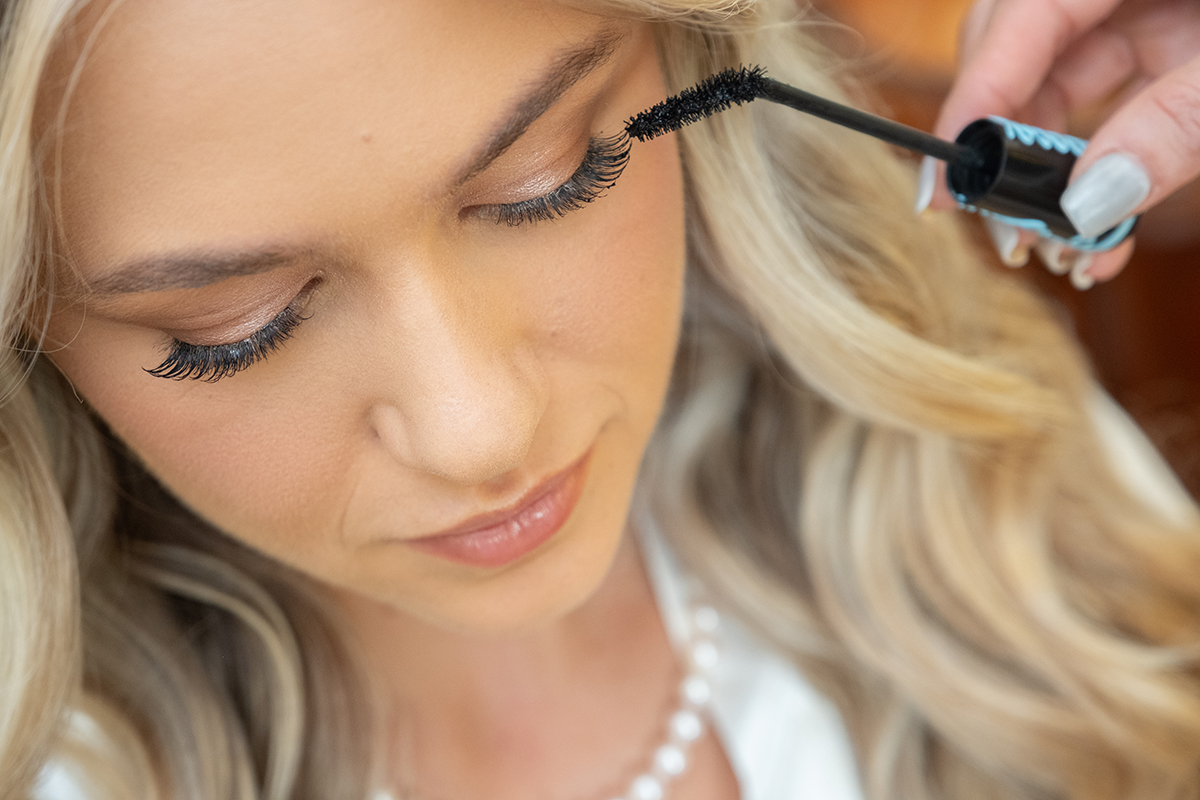 Close-up of bride applying mascara during wedding preparations at Bonnet House in Fort Lauderdale