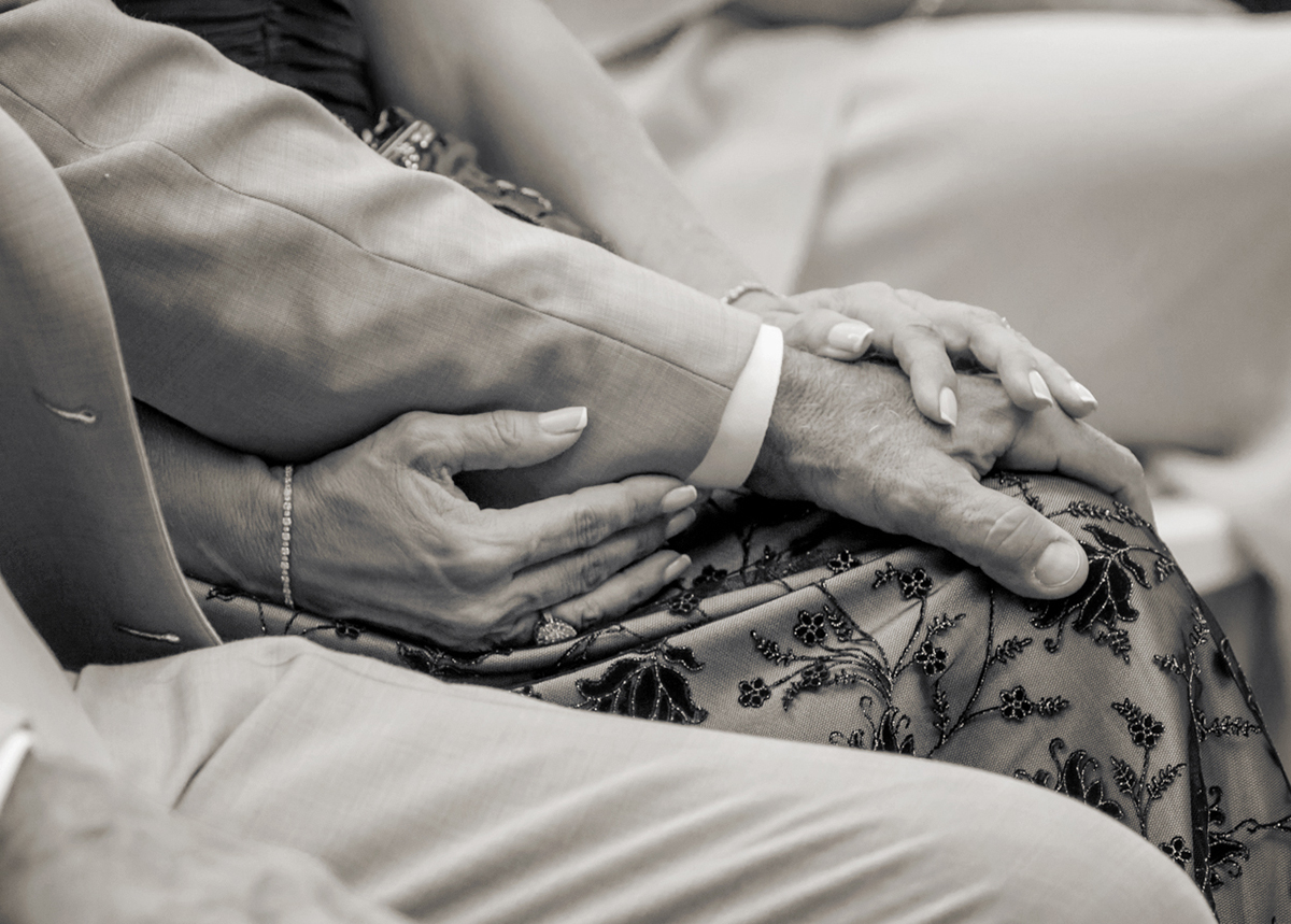 Black and white close-up of bride’s parents holding hands during Bonnet House wedding ceremony in Fort Lauderdale.