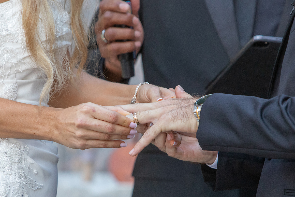 Close-up of bride placing wedding ring on groom’s finger during Bonnet House wedding ceremony in Fort Lauderdale with soft natural light and shallow depth of field.