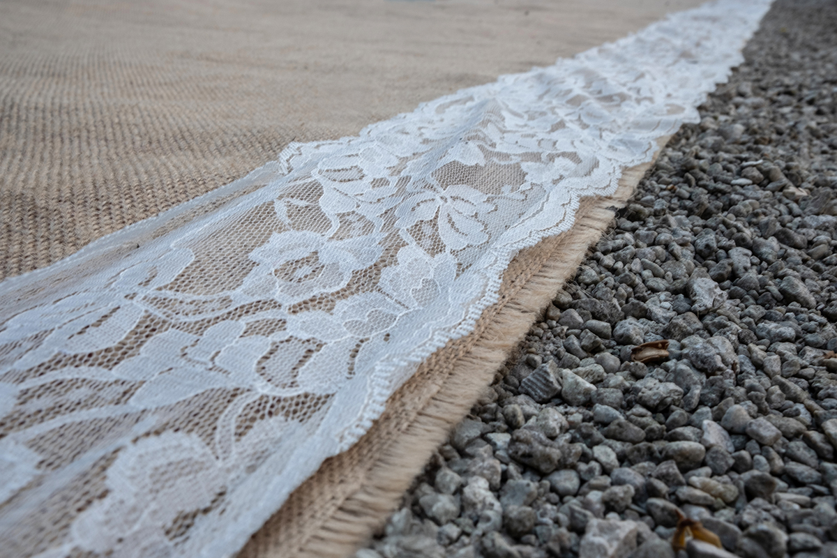 Close-up detail of lace aisle runner photographed at F16 for maximum depth of field during a Bonnet House Wedding ceremony.