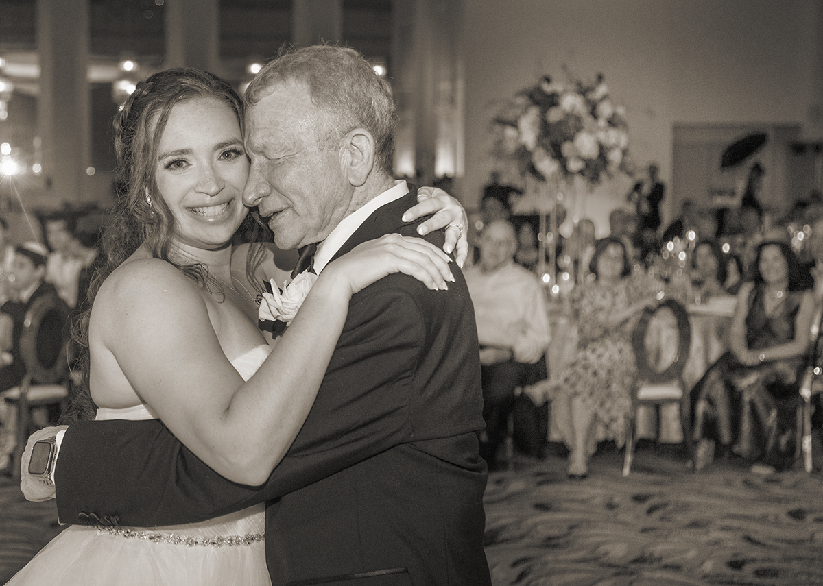 Bride sharing an emotional father-daughter dance during a Jewish wedding reception at Temple Beth Emet in Cooper City, Florida.