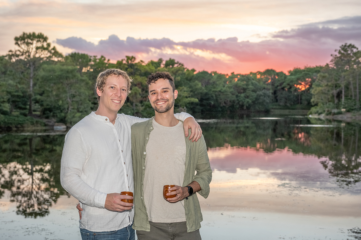 LGBTQ+ proposal photographer at Morikami Museum capturing Steve and Sam posing beside the lake at sunset after their surprise engagement in Delray Beach, Florida.