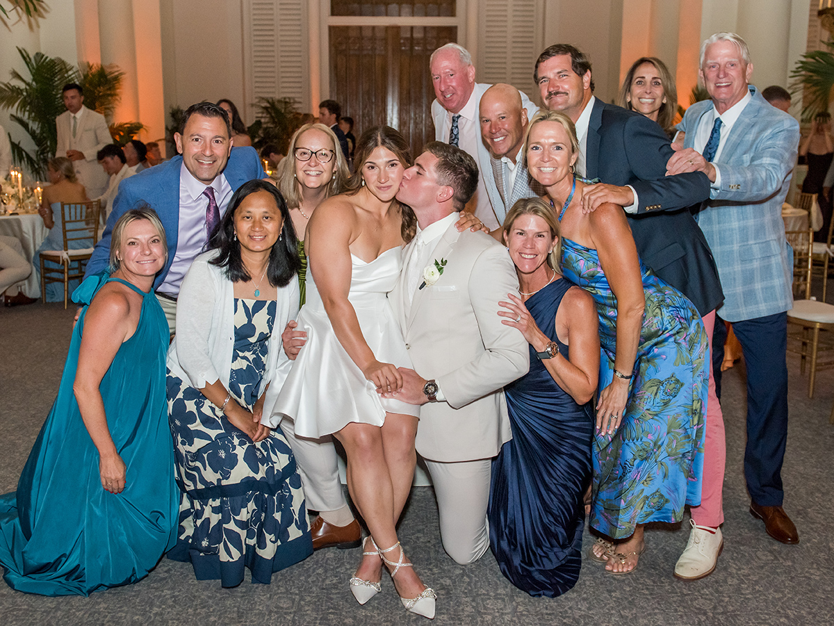 Bride and groom posing with wedding guests during a fast-paced Photo Blast at their reception at The Boca Raton in South Florida.