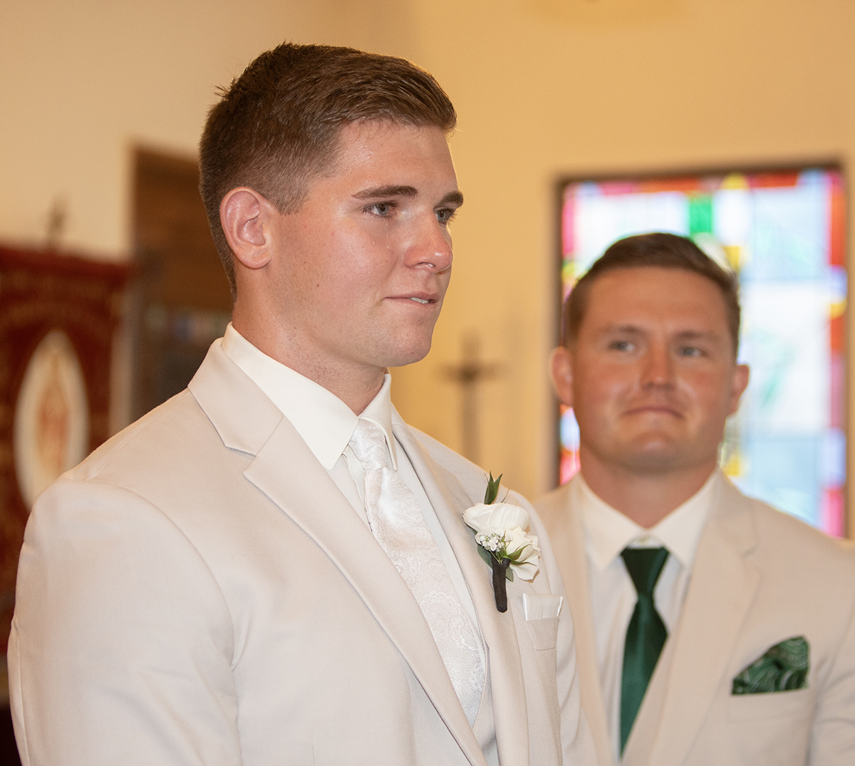 Groom David becomes emotional as he watches Catarina walk down the aisle during their Catholic wedding ceremony at Our Lady of Mercy Catholic Church in South Florida.