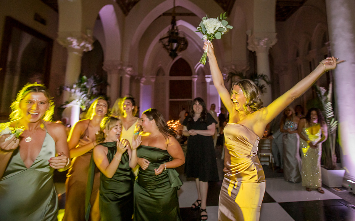 Bridesmaid celebrates after catching the bridal bouquet during the wedding reception at The Boca Raton.