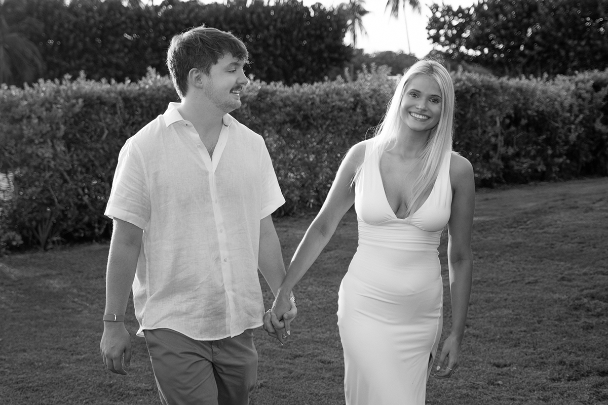 Josh and Rachael walking hand in hand during their engagement session at Red Reef Park in Boca Raton