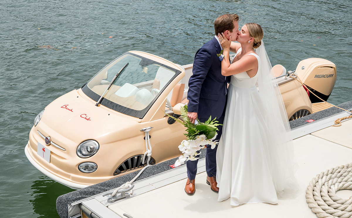 Bride and groom kiss on the dock after their waterfront first look at The Boca Raton Beach Club.