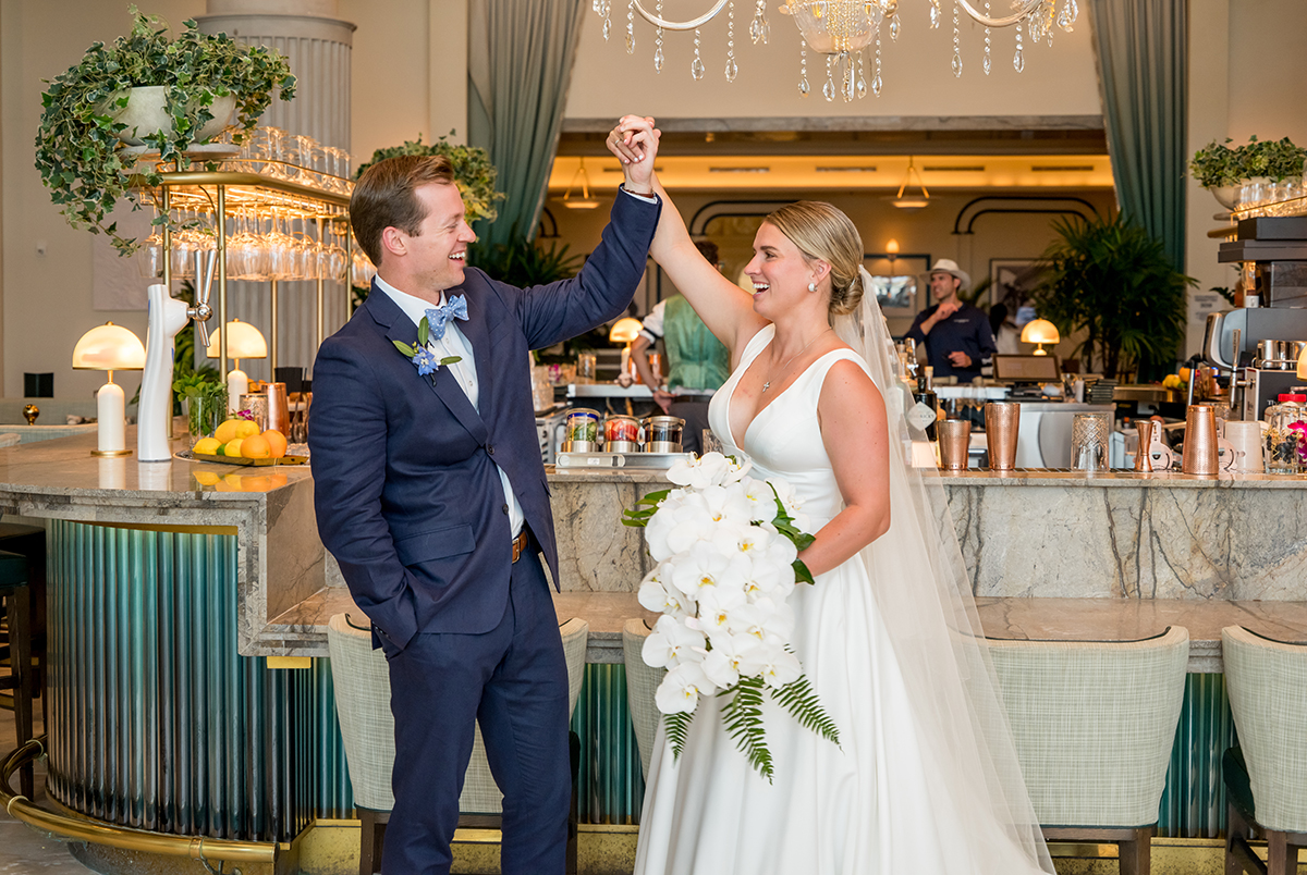 Katie and Jack sharing a playful moment inside the bar at The Boca Raton during their wedding portraits.