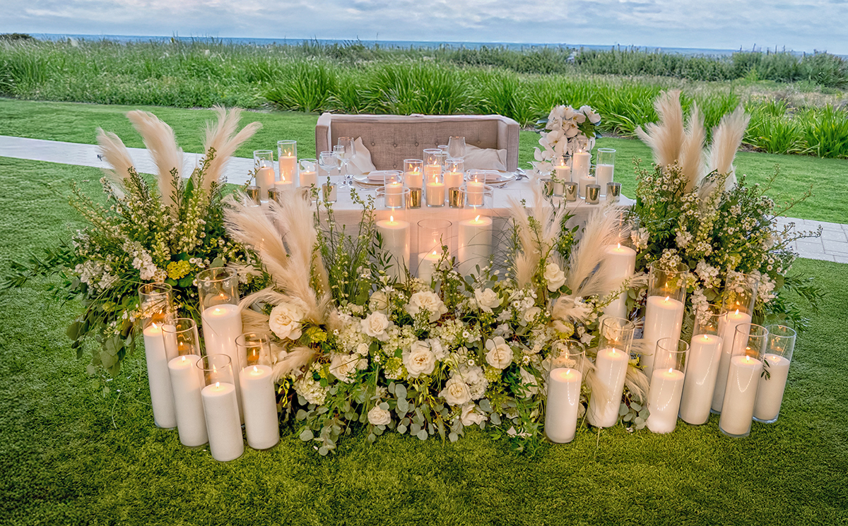 Bride and groom head table surrounded by white flowers and candlelight overlooking the ocean at The Boca Raton Beach Club.