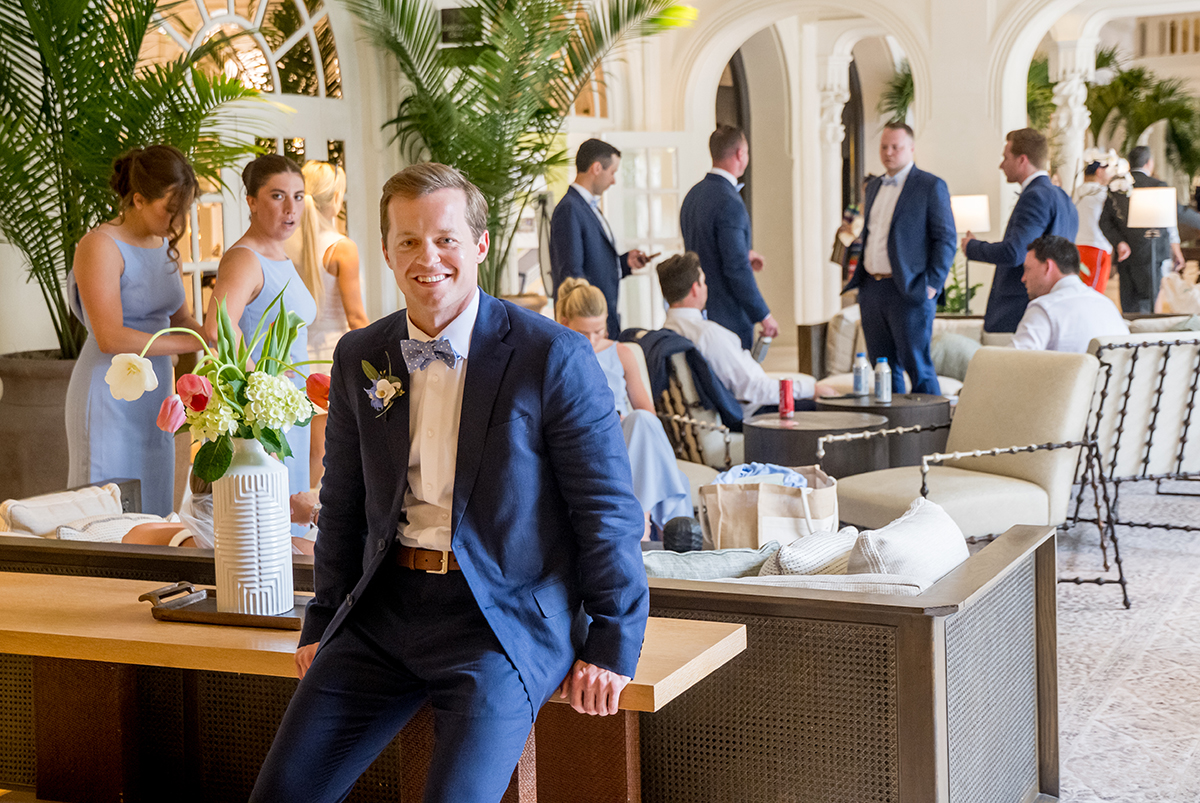 Groom relaxing in the lobby at The Boca Raton while family and wedding party gather for formal photographs.