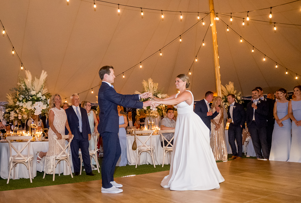 Katie and Jack share their first dance surrounded by guests inside their tented wedding reception at The Boca Raton Beach Club.