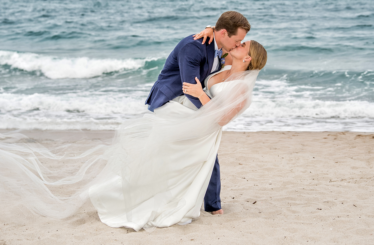 Bride and groom kissing on the beach during wedding portraits at The Boca Raton Beach Club.