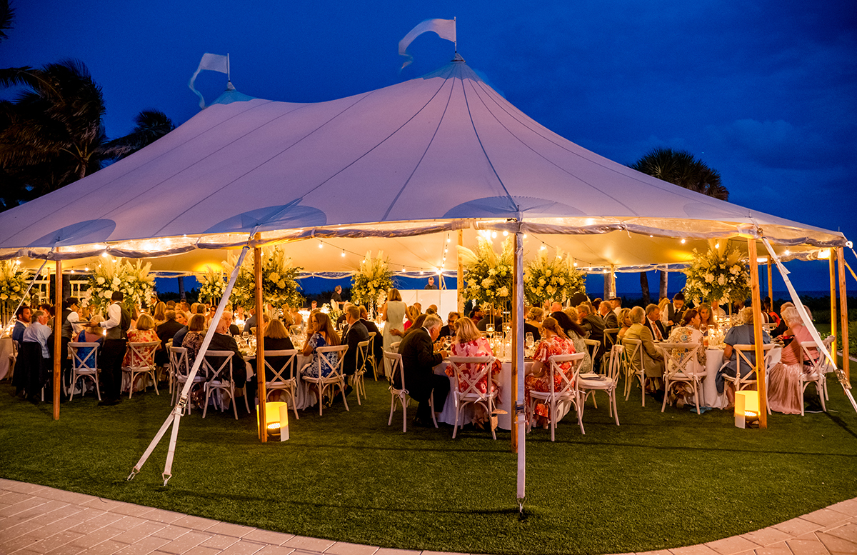 Illuminated outdoor wedding reception tent filled with dinner guests at The Boca Raton Beach Club.